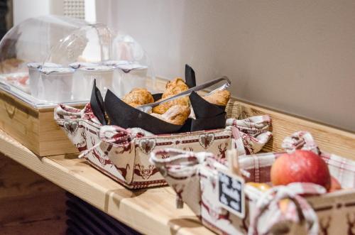 a basket of muffins and an apple on a table at AGRITURISMO La Giasena in Ponte nellʼAlpi