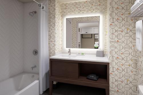 y baño con lavabo, espejo y bañera. en Holiday Inn & Suites - Hopkinsville - Convention Ctr, an IHG Hotel en Hopkinsville