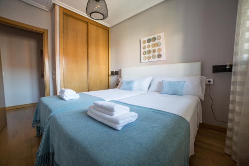 um quarto com 2 camas e toalhas em VUT Puro Sueño (Zurguen) em Salamanca