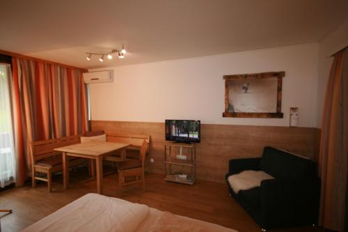 a living room with a couch and a table with a television at Appartements Domizil in Kaprun