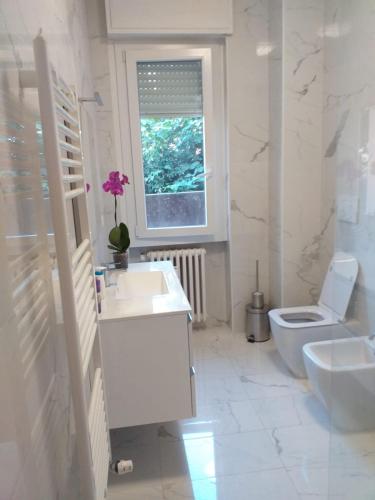 a white bathroom with a sink and a toilet at Sesto Calende Centro in Sesto Calende