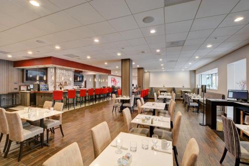 a restaurant with tables and chairs and a bar at Holiday Inn - Salem by IHG in Salem
