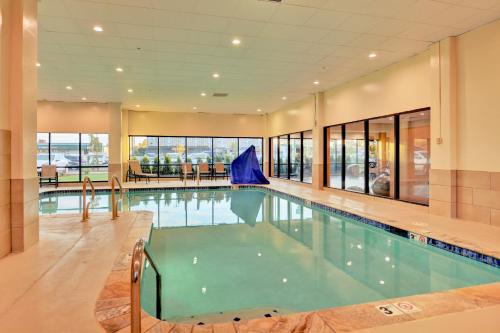 a large swimming pool in a building with windows at Holiday Inn - Salem by IHG in Salem