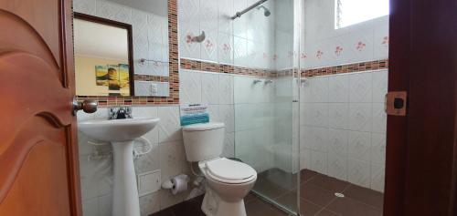 a bathroom with a toilet and a sink at Hotel Dubai in Manizales