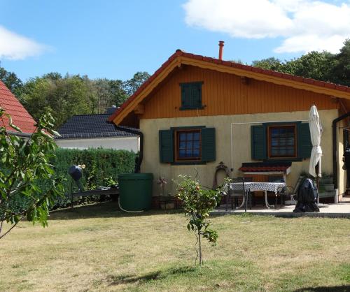 een huis met een tuin met een tafel en stoelen bij Haus am Mühlenberg in Deetz