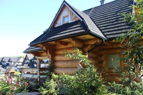 a log cabin with a roof on top of it at Domki w Białce pod Basenami, 50 m od term i wyciągów in Białka Tatrzanska