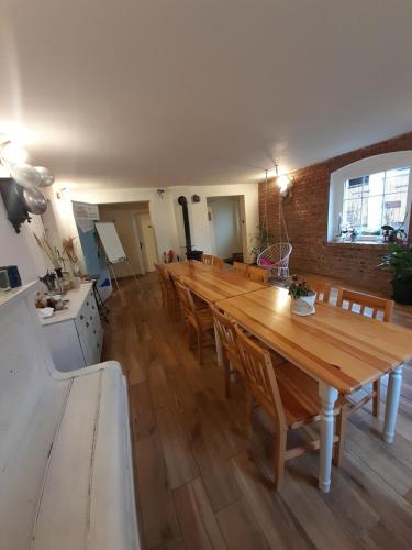 a dining room with a long wooden table and chairs at Dom O Niebieskich Okiennicach in Gryfów Śląski