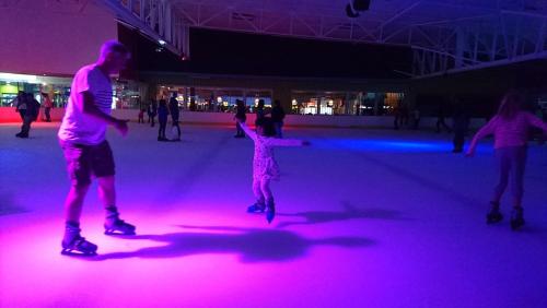 a group of people skating on an ice rink with pink lights at Sancta Maria 10 - Ultimate in luxury & majestic sea views includes private entertainment deck - Free wifi in Kingsburgh