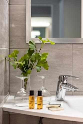 a bathroom sink with a vase with a plant on it at Ludvika Stadshotell in Ludvika
