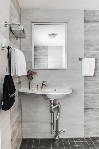 a bathroom with a sink and a mirror at Ludvika Stadshotell in Ludvika
