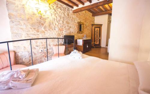 a bedroom with a bed and a stone wall at B&B Antica Gabella in Castiglione del Lago