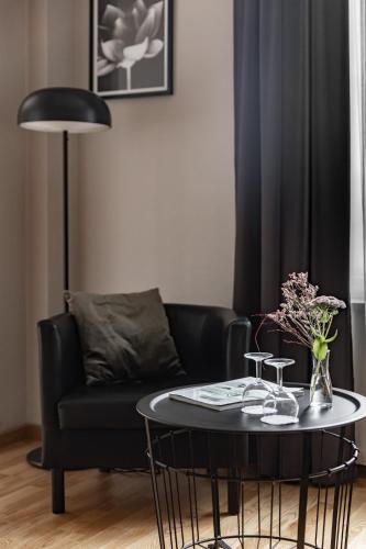 a living room with a black couch and a table at Ludvika Stadshotell in Ludvika