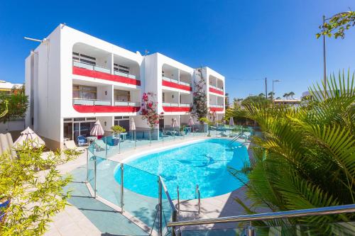 un hôtel avec une piscine en face d'un bâtiment dans l'établissement Apartamentos Bogota, à Playa del Ingles