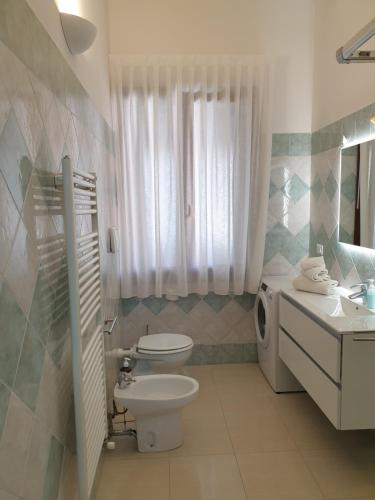 biała łazienka z toaletą i umywalką w obiekcie Cottage al mare Martina w Lido di Venezia