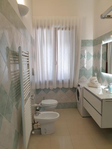 a white bathroom with a toilet and a sink at Cottage al mare Martina in Venice-Lido