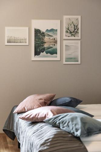 a bedroom with a bed with four pictures on the wall at Ludvika Stadshotell in Ludvika