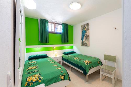 - une chambre avec 2 lits et des murs verts dans l'établissement Apartamentos Bogota, à Playa del Ingles