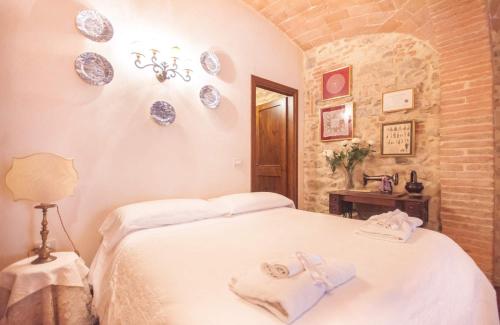 a bedroom with a bed and plates on the wall at B&B Antica Gabella in Castiglione del Lago