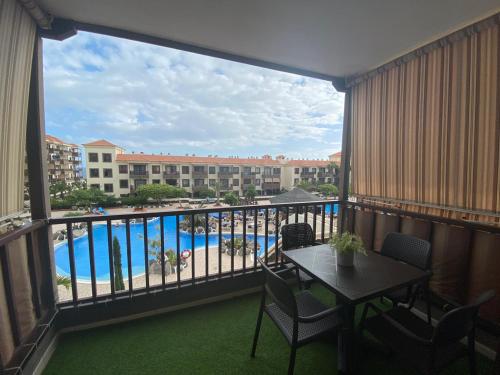 een balkon met een tafel en uitzicht op een zwembad bij Wait and Sea Apartment Costa del Silencio Tenerife in Arona