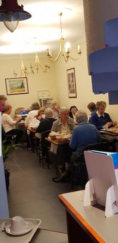 un grupo de personas sentadas en mesas en un restaurante en Le Clémenceau Hôtel et Appart 'hôtel "Gare Sncf" centre ville, en Valenciennes
