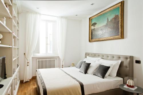 sypialnia z łóżkiem z obrazem na ścianie w obiekcie Garibaldi Suites Piazza Di Spagna w Rzymie
