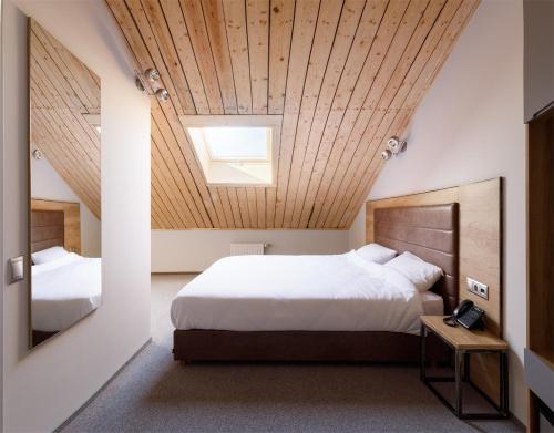 モスクワにあるTurris Hotel Taganskyの木製の天井のベッドルーム1室(大型ベッド1台付)