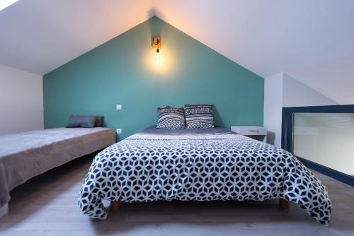 a bedroom with a bed with a black and white comforter at Gîte L'Atelier de Tournerie in Montigny-sur-lʼAin