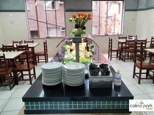 a restaurant with a counter with plates on it at Colina Park Hotel in Aparecida
