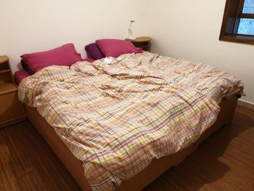 a bed with a plaid comforter in a bedroom at נוף הרים Mountain View in Neve Daniel