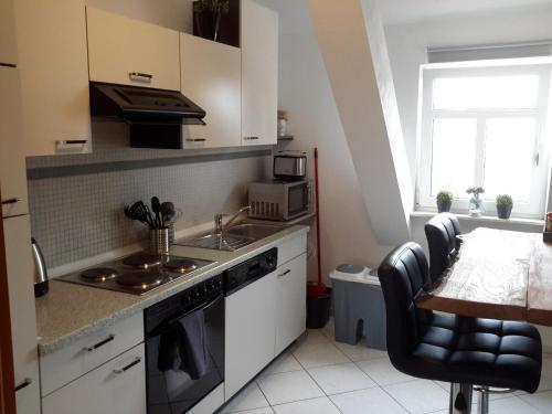 een keuken met een wastafel en een fornuis top oven bij Appartement Luthers Stübchen in Lutherstadt Wittenberg