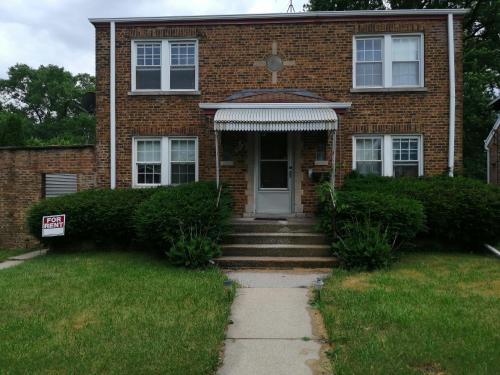 una casa de ladrillo con una puerta y un cartel delante en 834 Happy Home -Peaceful Private RMs with Laundry en Chicago Heights