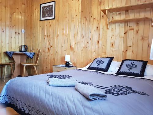 1 dormitorio con 1 cama con sábanas azules y paredes de madera en Spanie po Zbóju en Kościelisko