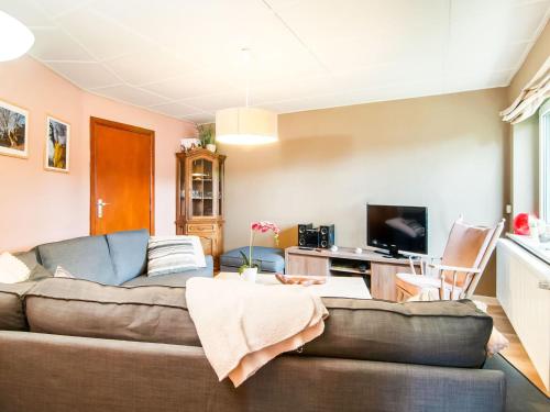 uma sala de estar com um sofá e uma televisão em Tranquil Holiday Home with Private Garden em Krinkelt