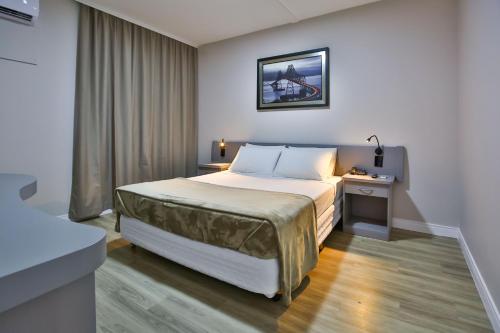 a hotel room with a bed and a window at Vivendas Rio Claro by Atlantica in Rio Claro