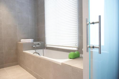a bath tub sitting next to a window in a bathroom at Hotel Domus in Boom