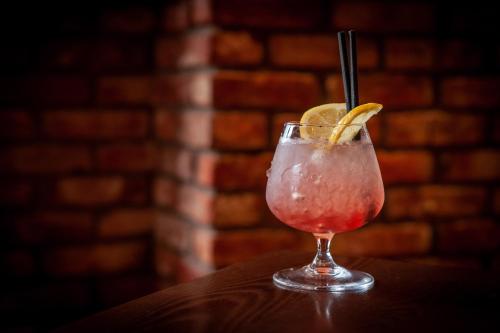 a drink with a lemon slice in a glass on a table at Holiday Inn - Glasgow - City Ctr Theatreland by IHG in Glasgow