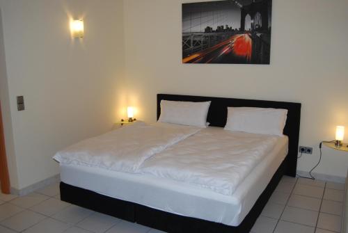 ein Bett in einem Schlafzimmer mit zwei Lichtern an der Wand in der Unterkunft Ferienwohnung-Zierenberg in Zierenberg