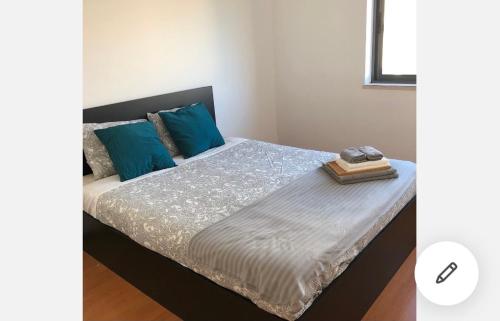 ein Schlafzimmer mit einem Bett mit blauen Kissen in der Unterkunft Wonderful apartament Lisbon in Montijo