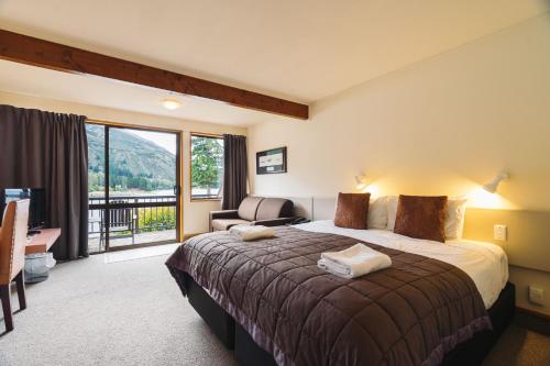 a hotel room with a bed and a balcony at Hawea Hotel in Wanaka