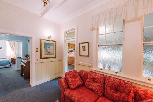a living room with a red couch and a window at Fitzroy Motor Inn in Grafton