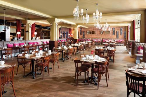 a dining room with tables and chairs and chandeliers at The Fives Beach Hotel & Residences - All Senses Inclusive in Playa del Carmen