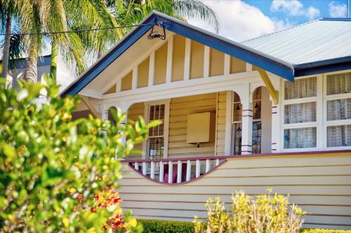 a small white house with a porch and a balcony at Fitzroy Motor Inn in Grafton