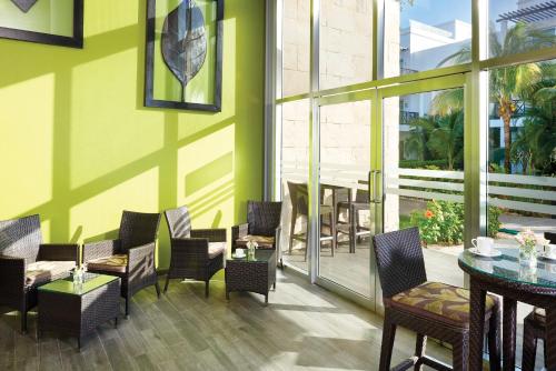 a restaurant with chairs and tables and a patio at The Fives Beach Hotel & Residences - All Senses Inclusive in Playa del Carmen