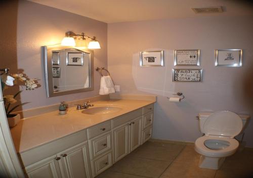 a bathroom with a sink and a toilet and a mirror at Modern Cottage Style in Tempe