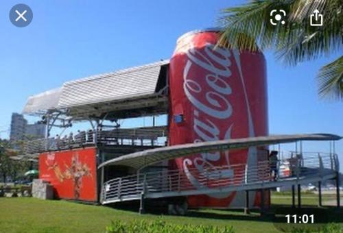 una cocacola puede sentarse en la parte superior de un autobús en Flat -Hidromassagem privativa e Piscina a 500 mts da praia en São Vicente