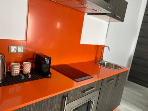 une cuisine avec un comptoir orange et un téléphone dans l'établissement Apartamentos "El Escondite de Triana", à Séville