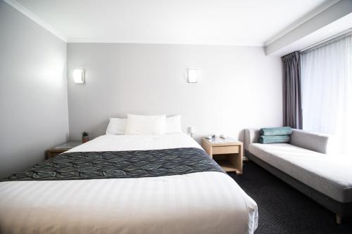 a hotel room with a bed and a couch at Madison Capital Executive Apartments in Canberra