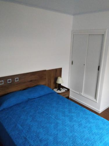 a bedroom with a blue bed and a cabinet at Posada La Nona in Minas