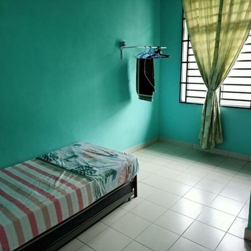 a blue room with a bed and a window at Ms Homestay jeli in Jeli