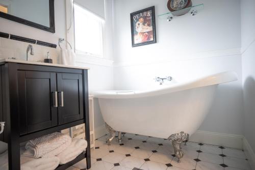 a white bathroom with a tub and a sink at Canungra Cottages - Boutique Bed and Breakfast in Canungra